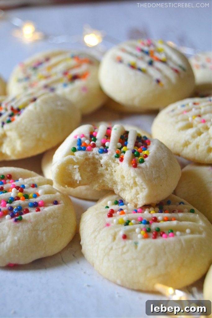 Arrangement of shortbread cookies on a white plate, one with a bite missing