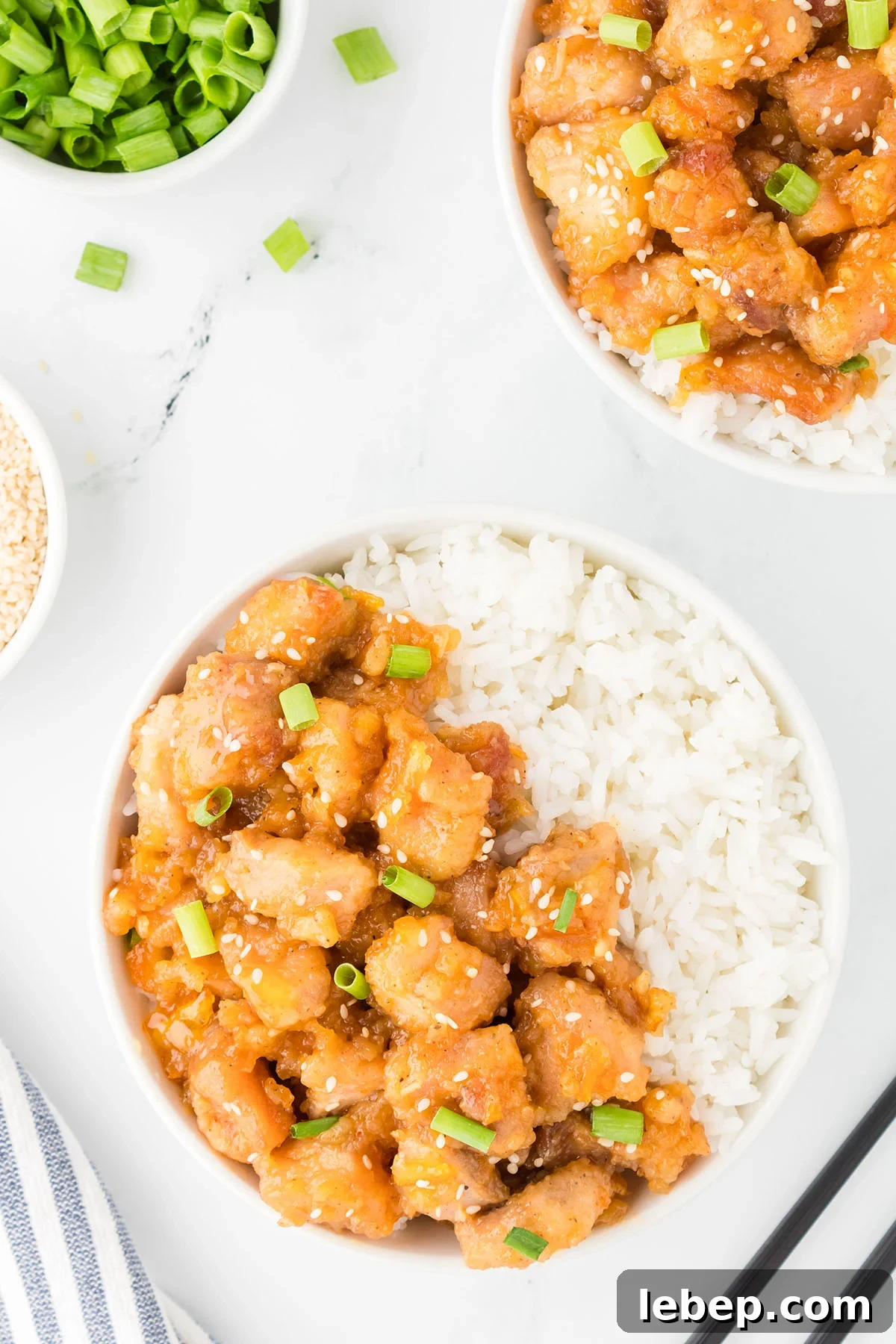 Orange Chicken served in a white bowl with white rice.