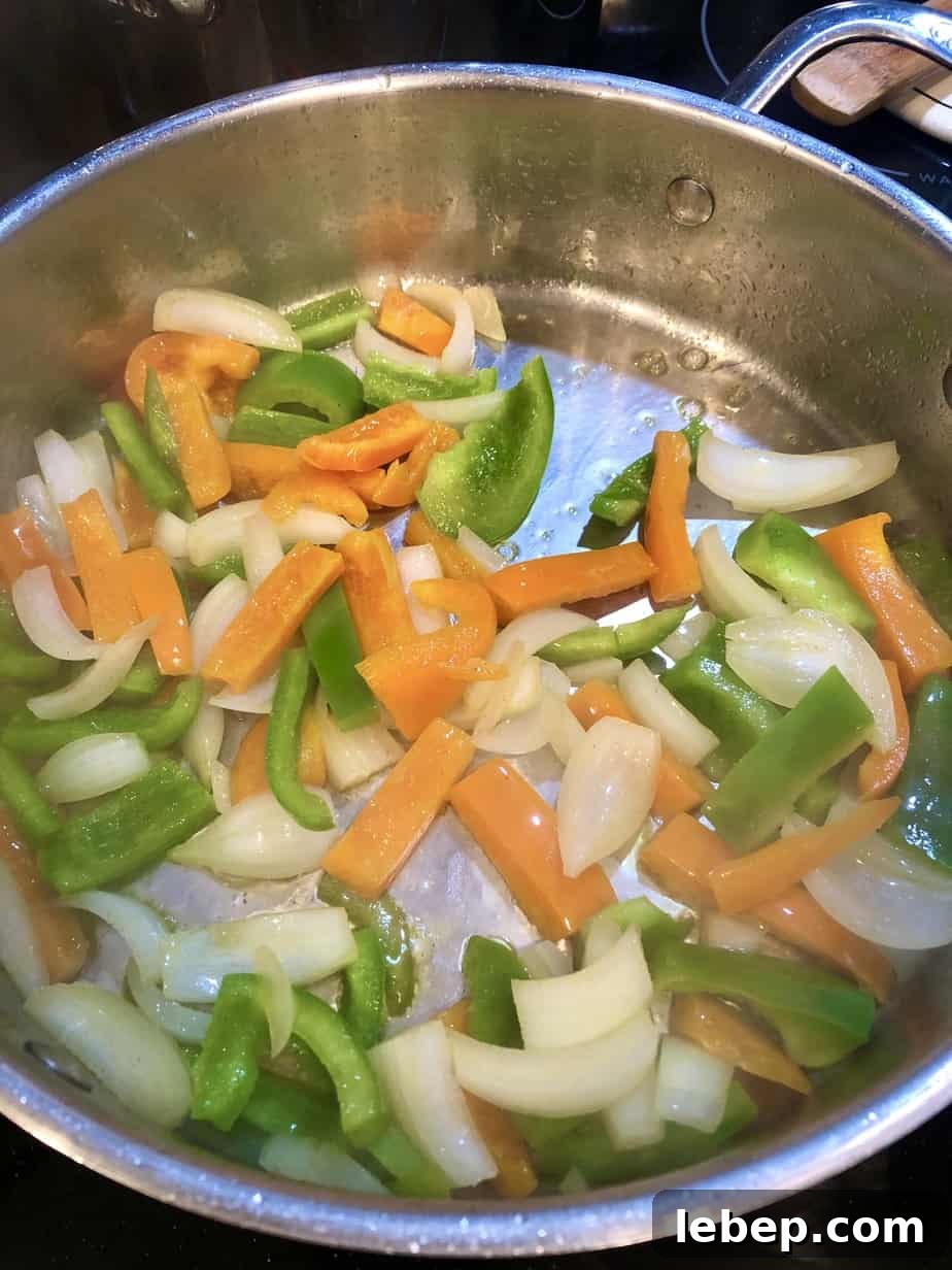 chopped veggies cooking in stainless steel skillet