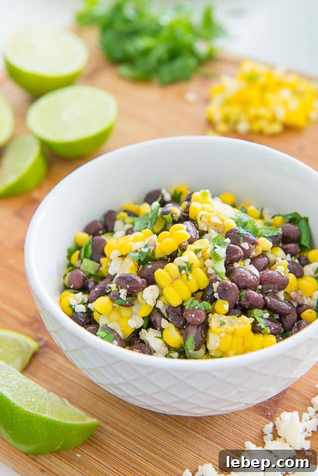 20+ Picnic and Potluck Salads That Stay Fresh and Travel Well 13 Mexican Black Bean Corn Salad in Bowl with Lime Wedges on Side
