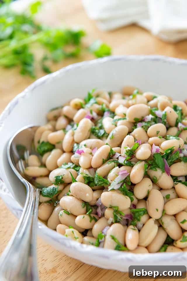 20+ Picnic and Potluck Salads That Stay Fresh and Travel Well 16 White Bean Salad - in White Low Bowl With Herbs, Lemon, and Red Onion
