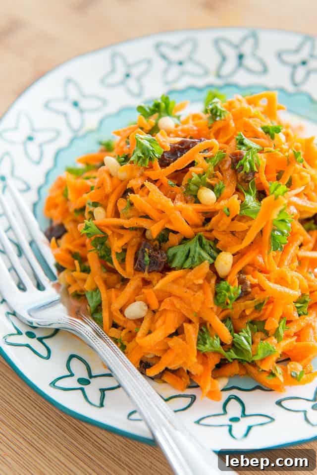 20+ Picnic and Potluck Salads That Stay Fresh and Travel Well 5 Carrot Raisin Salad - On a Blue Plate with Fork
