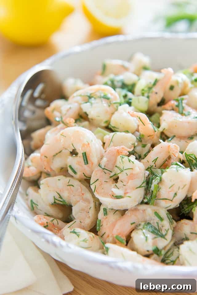 20+ Picnic and Potluck Salads That Stay Fresh and Travel Well 6 A big white bowl filled with shrimp salad studded with celery and dill