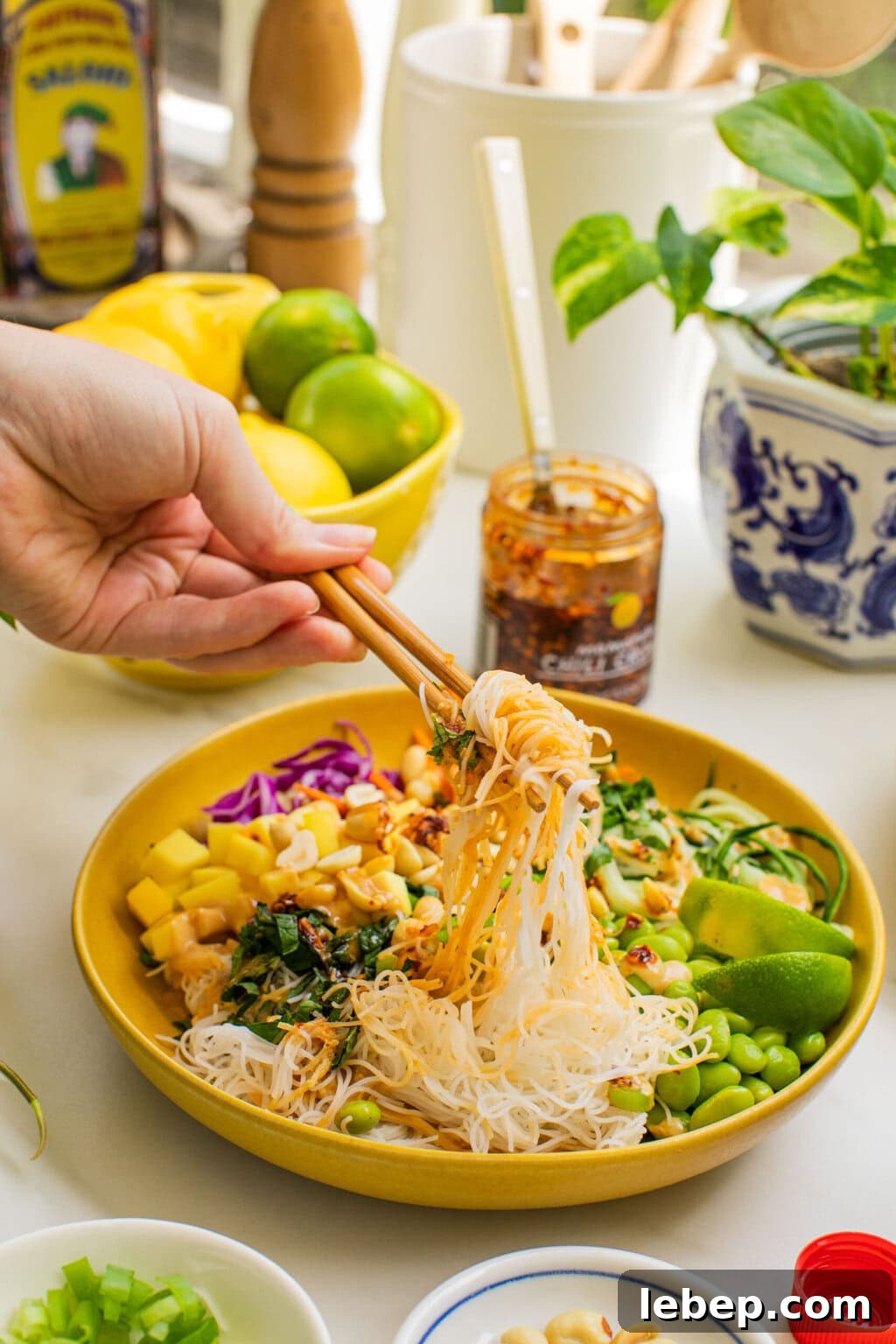 Spring Roll Bowl Recipe: Fresh Vietnamese Salad Bowl with Dipping Sauce 2 a bowl of spring roll ingredients that someone is taking a bite out of with chopsticks