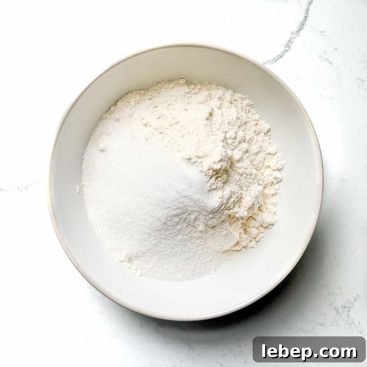 Adding the dry ingredients to a white bowl. 