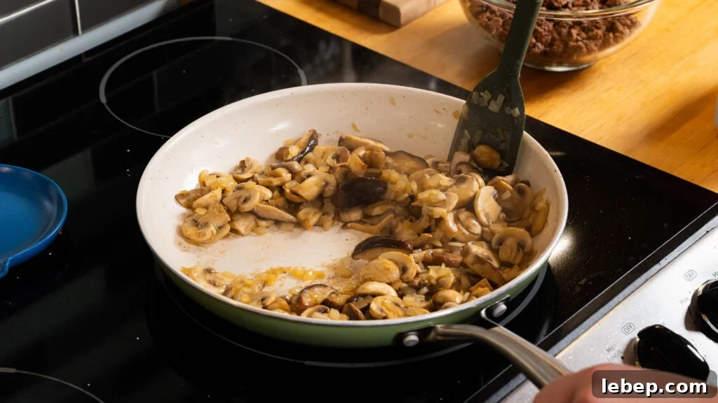Classic Ground Beef Stroganoff with Egg Noodles Recipe 4 Sauteeing mushrooms in a skillet for an easy beef stroganoff recipe.