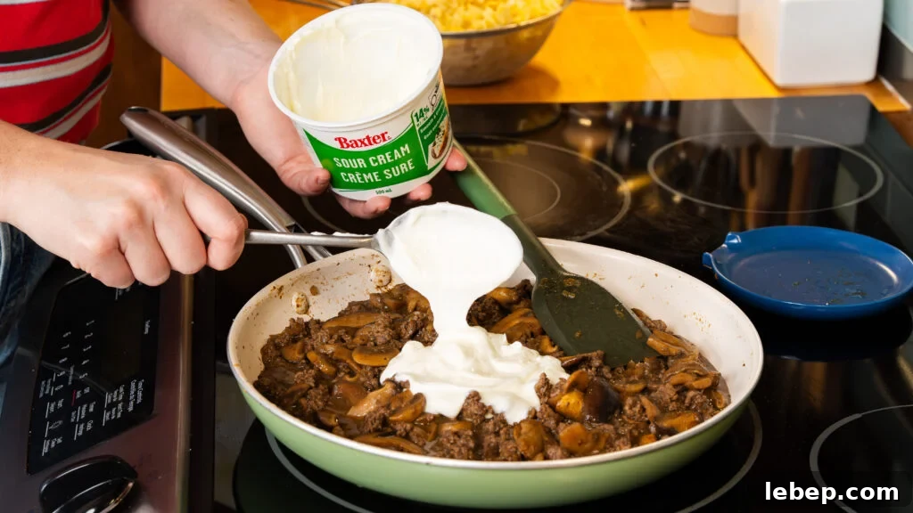 Classic Ground Beef Stroganoff with Egg Noodles Recipe 7 Adding sour cream to this ground beef stroganoff skillet.