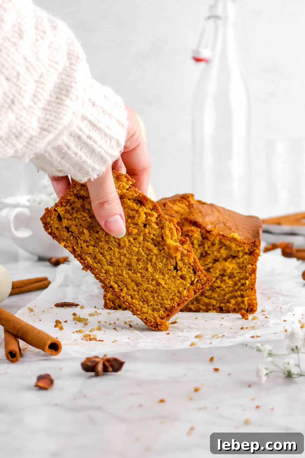 Moist Pumpkin Bread Recipe with Warm Spices 3 hand holding slice of pumpkin bread