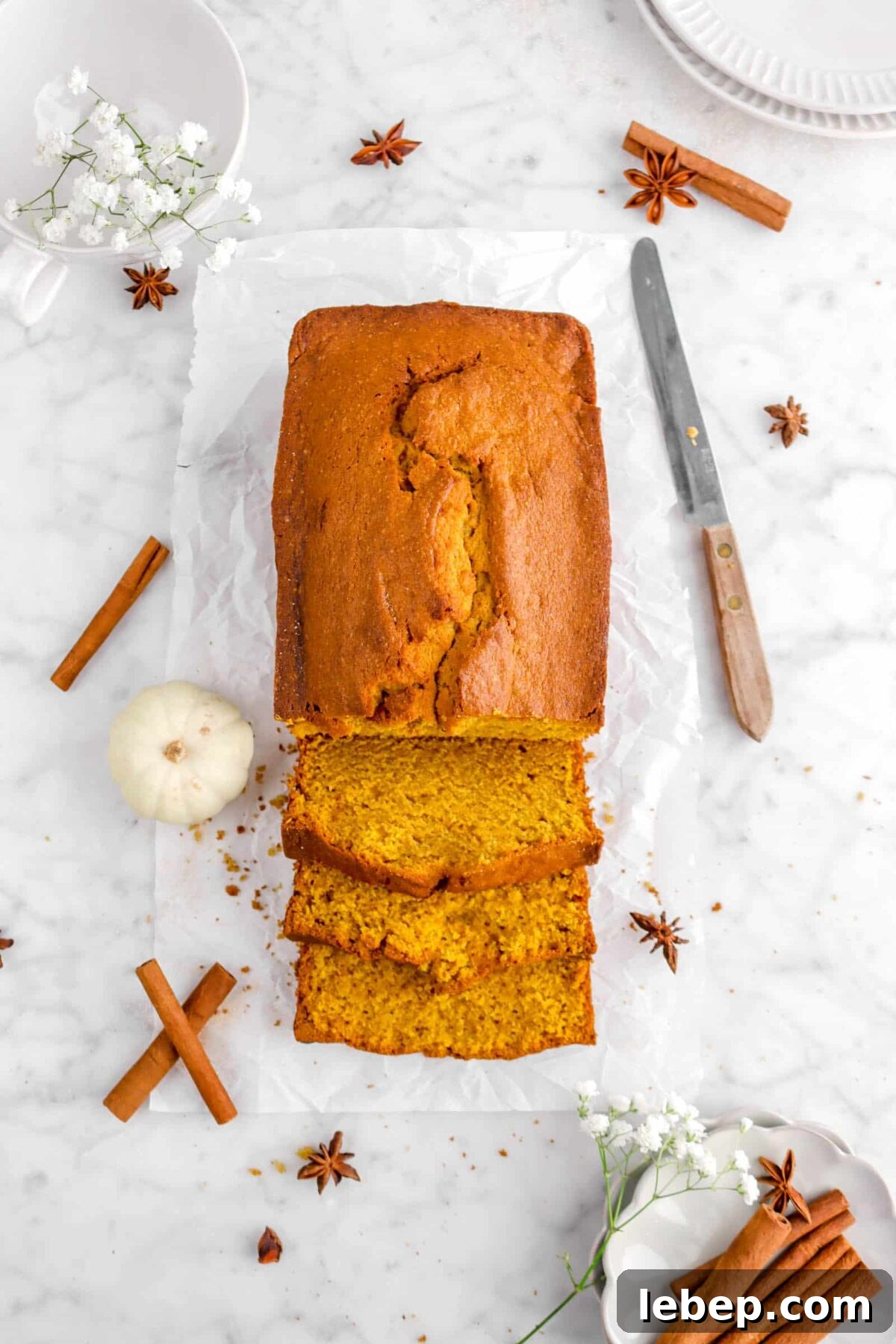 Moist Pumpkin Bread Recipe with Warm Spices 19 overhead of pumpkin bread with whole spices, mini pumpkin, and knife
