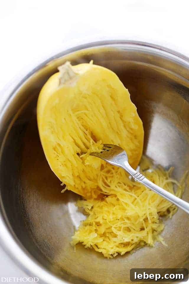 Shredding spaghetti squash with a fork.