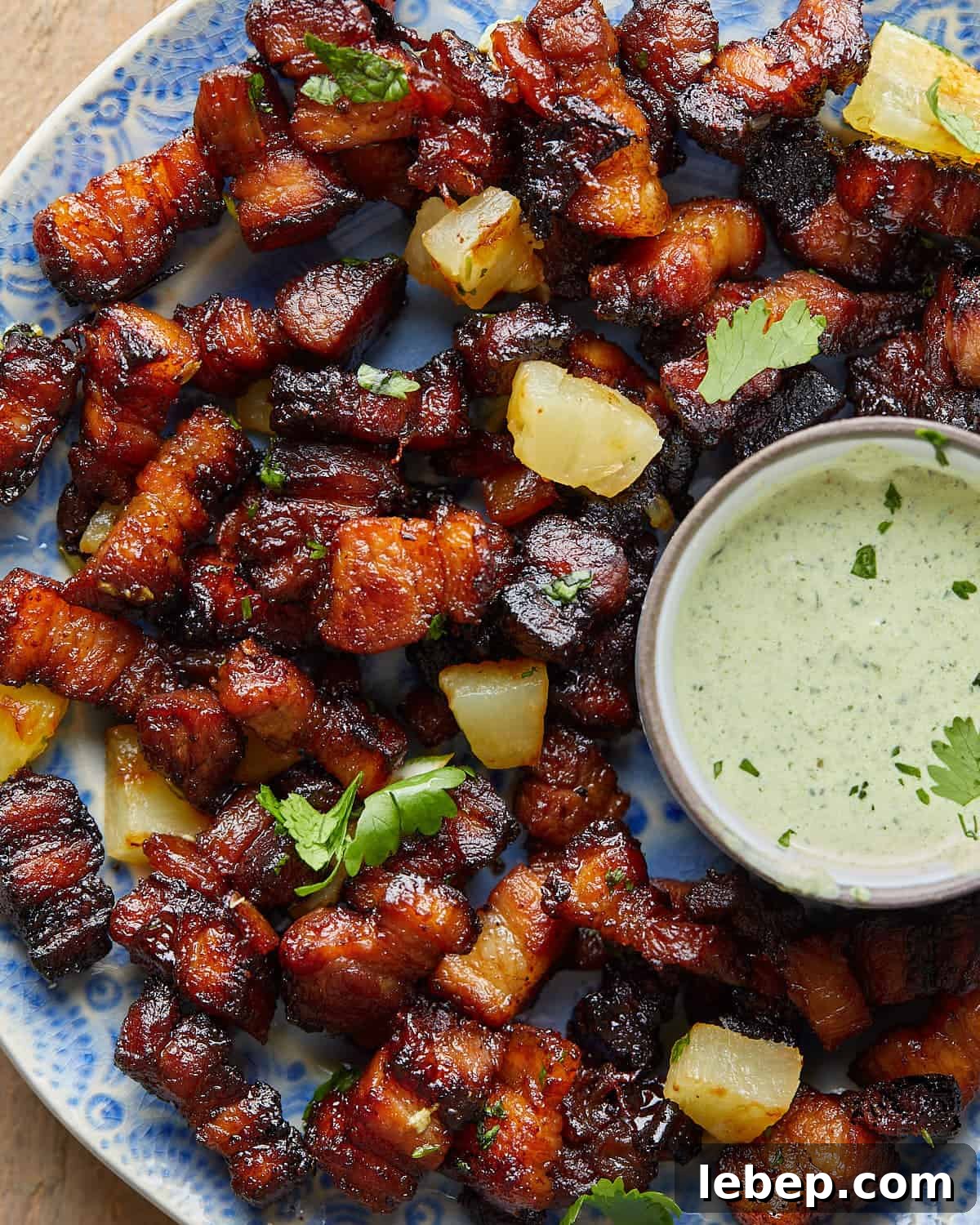 Overhead image of air fryer pork belly bites with garnish.