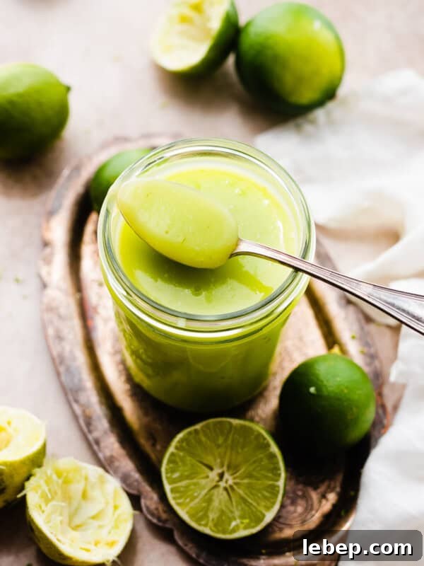 Key Lime Pie Cookies with Make-Ahead Prep Tips 12 A spoon resting on a jar of bright green lime curd.