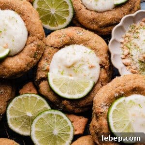Key Lime Pie Cookies with Make-Ahead Prep Tips 14 A close-up of the key lime pie cookies nestled together on a cooling rack, with slices of lime for garnish.
