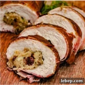 Bacon wrapped turkey breast roulade sliced and lined up on a wooden cutting board.