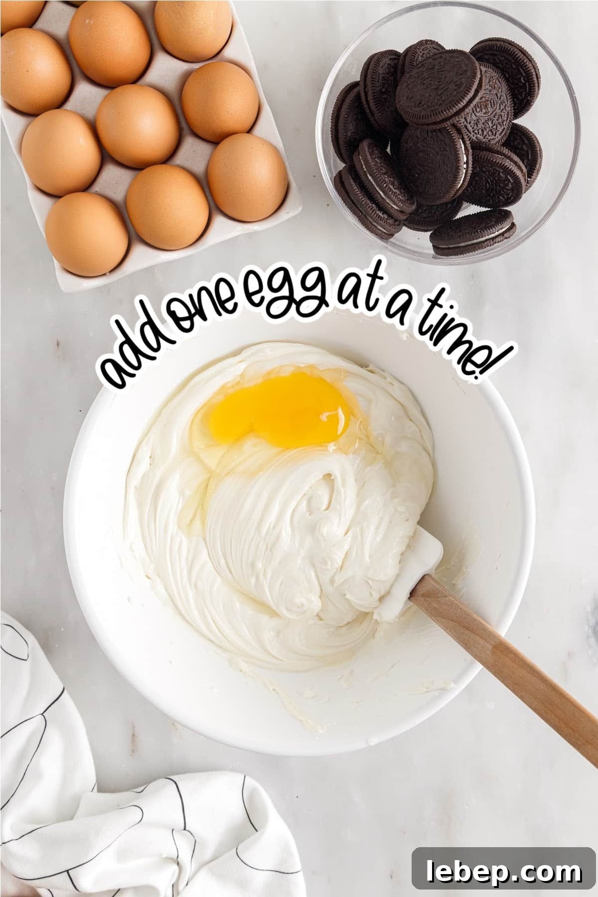 Adding one egg at a time to the cheesecake mixture, with text overlay.