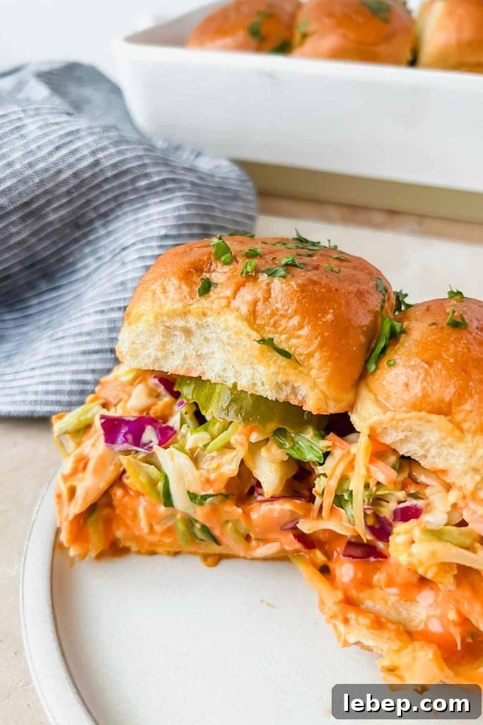 two buffalo chicken sliders on white serving plate.