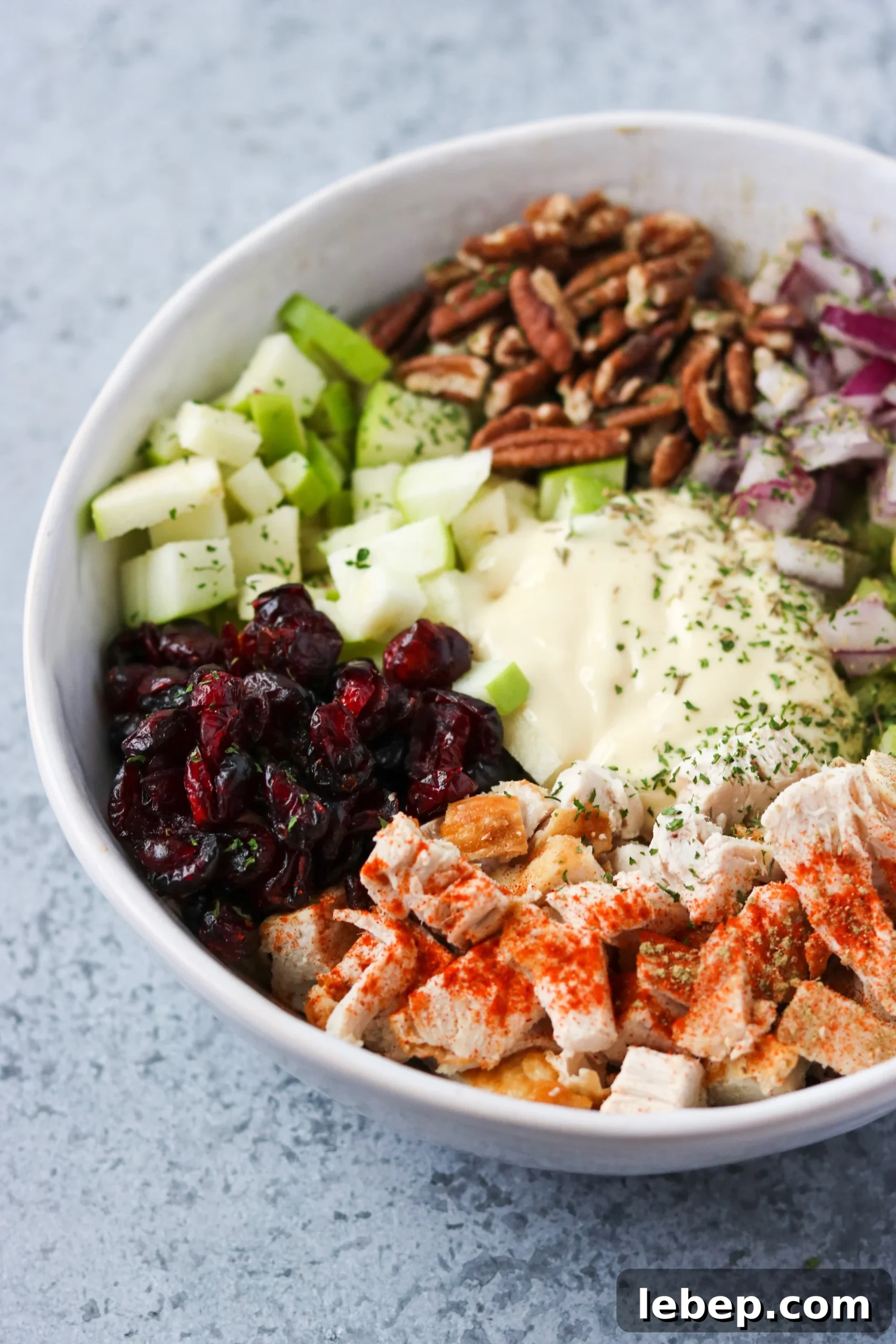 ingredients for pecan cranberry chicken salad in a white bowl
