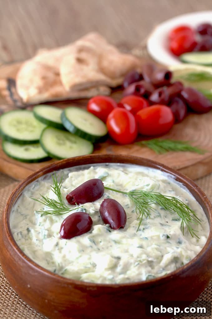 Authentic Greek Tzatziki Sauce Recipe — Creamy Cucumber Yogurt Dip 2 A wooden bowl with creamy Greek Tzatziki sauce