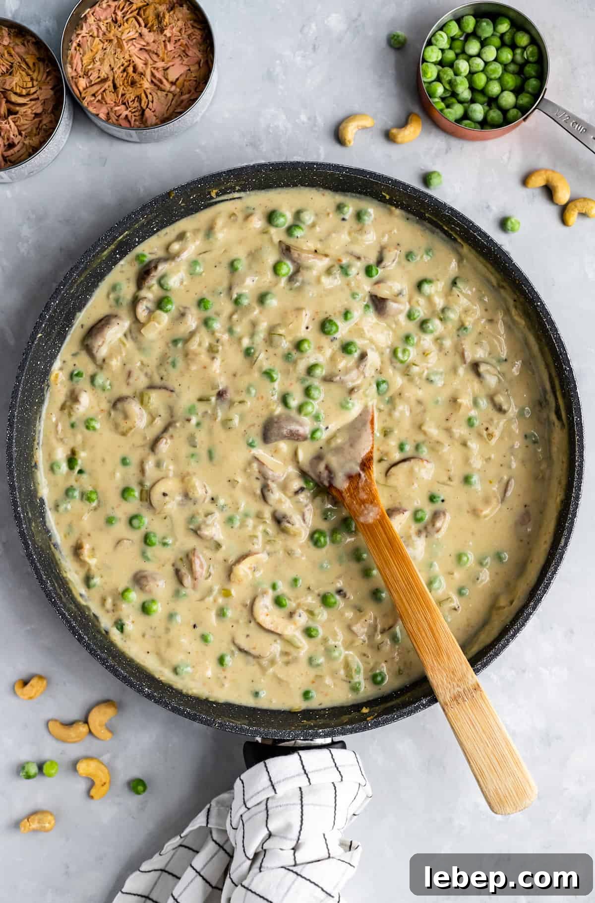 black pan with sauce and peas and wooden spoon