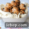 Cherry vanilla energy balls stacked in a tan bowl.