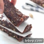 Fingers placing a mint chocolate protein bar onto a stack.