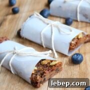 Three date energy bars wrapped in parchment paper.
