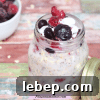 Dairy-free overnight oats in a mason jar topped with frozen berries.