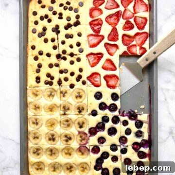 sheet pan pancakes cut into slices with spatula on pan.