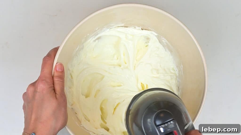 Beating mascarpone and cream with an electric hand mixer