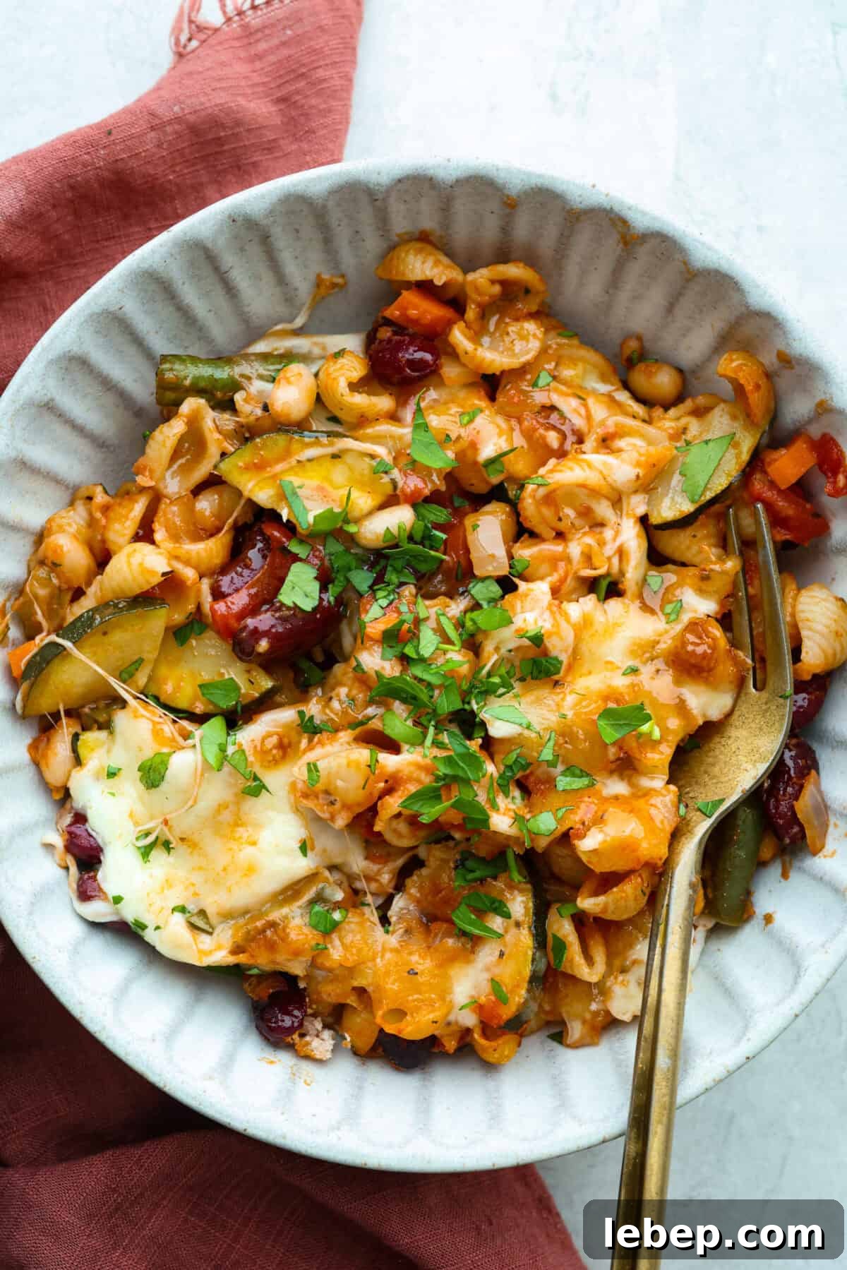 Hearty Minestrone Casserole Recipe for Comforting Family Dinners 3 Serving portion of minestrone casserole with a gold fork.