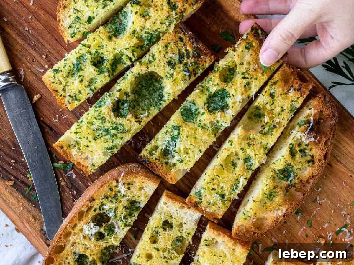 Crispy Ciabatta Garlic Bread Recipe with Herb Butter 6 Slices of herby toasted ciabatta bread showing fingers taking a slice viewed from above.
