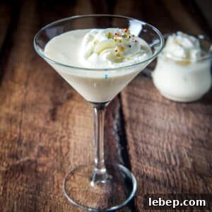 A classic glass filled with the creamy cocktail with whipped cream and sprinkles - square