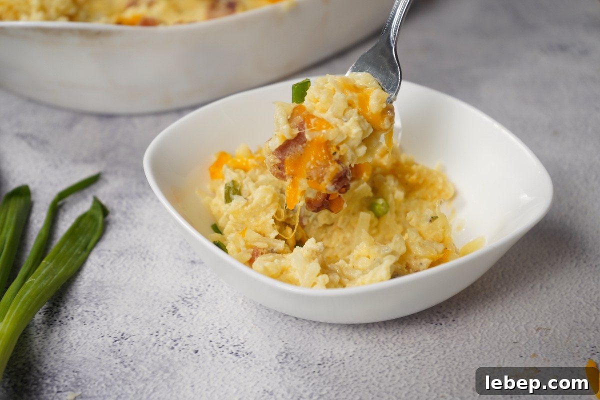 Cheesy potatoes in bowl with fork