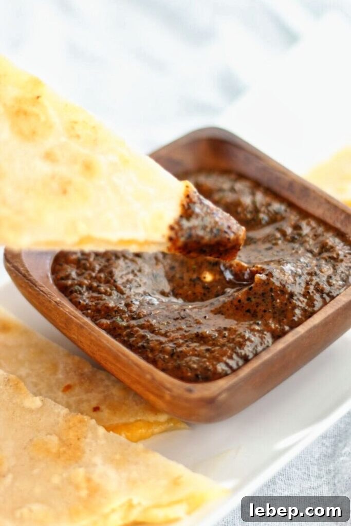 Homemade Baja Fresh-Style Salsa Recipe — Fresh & Zesty Flavor 2 quesadilla dipped into copycat baja fresh salsa in wooden square bowl