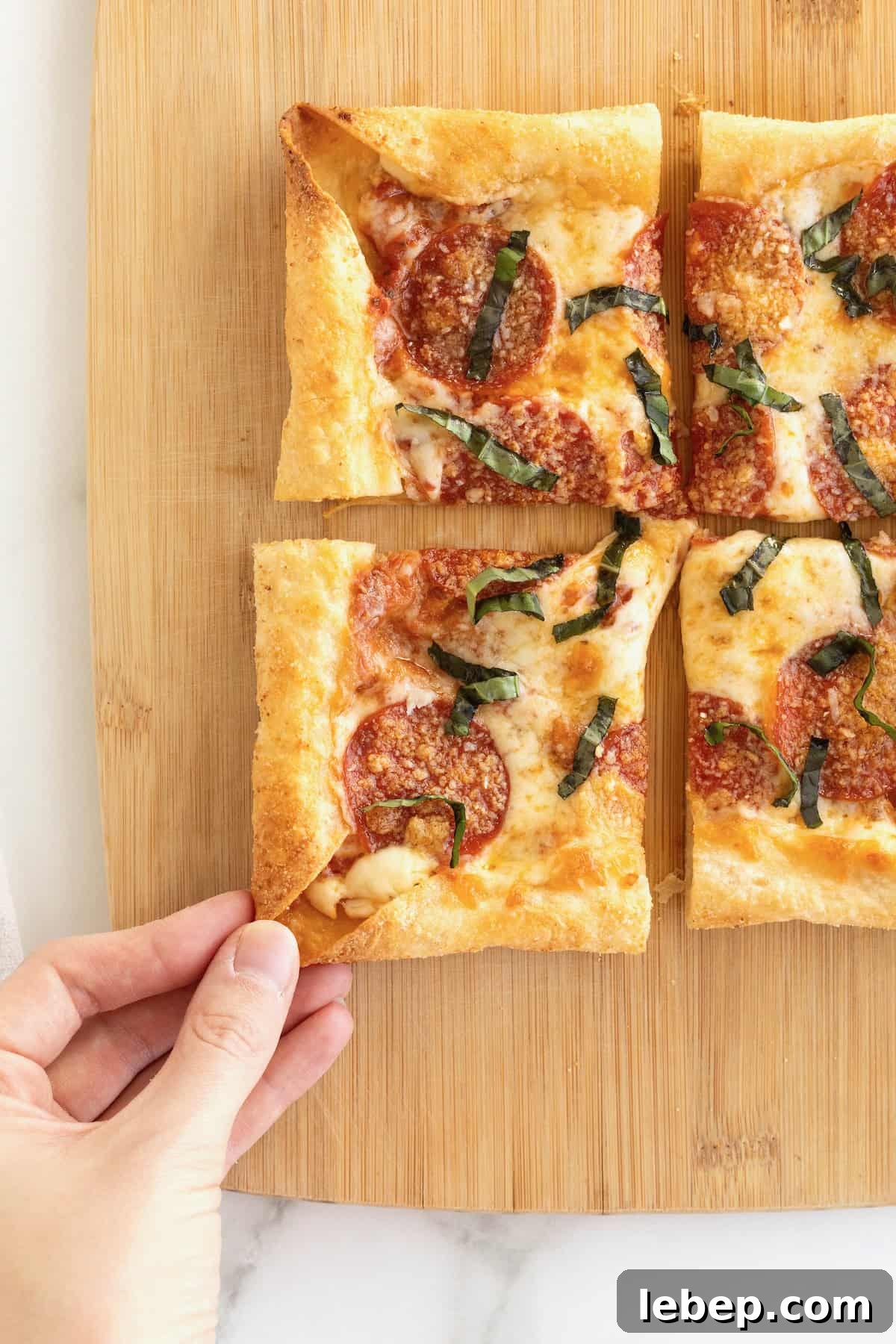 A stuffed crust tortilla pizza on a rectangular light wood cutting board.