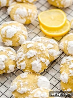 lemon crinkle cookies with confectioners sugar piled on wire rack