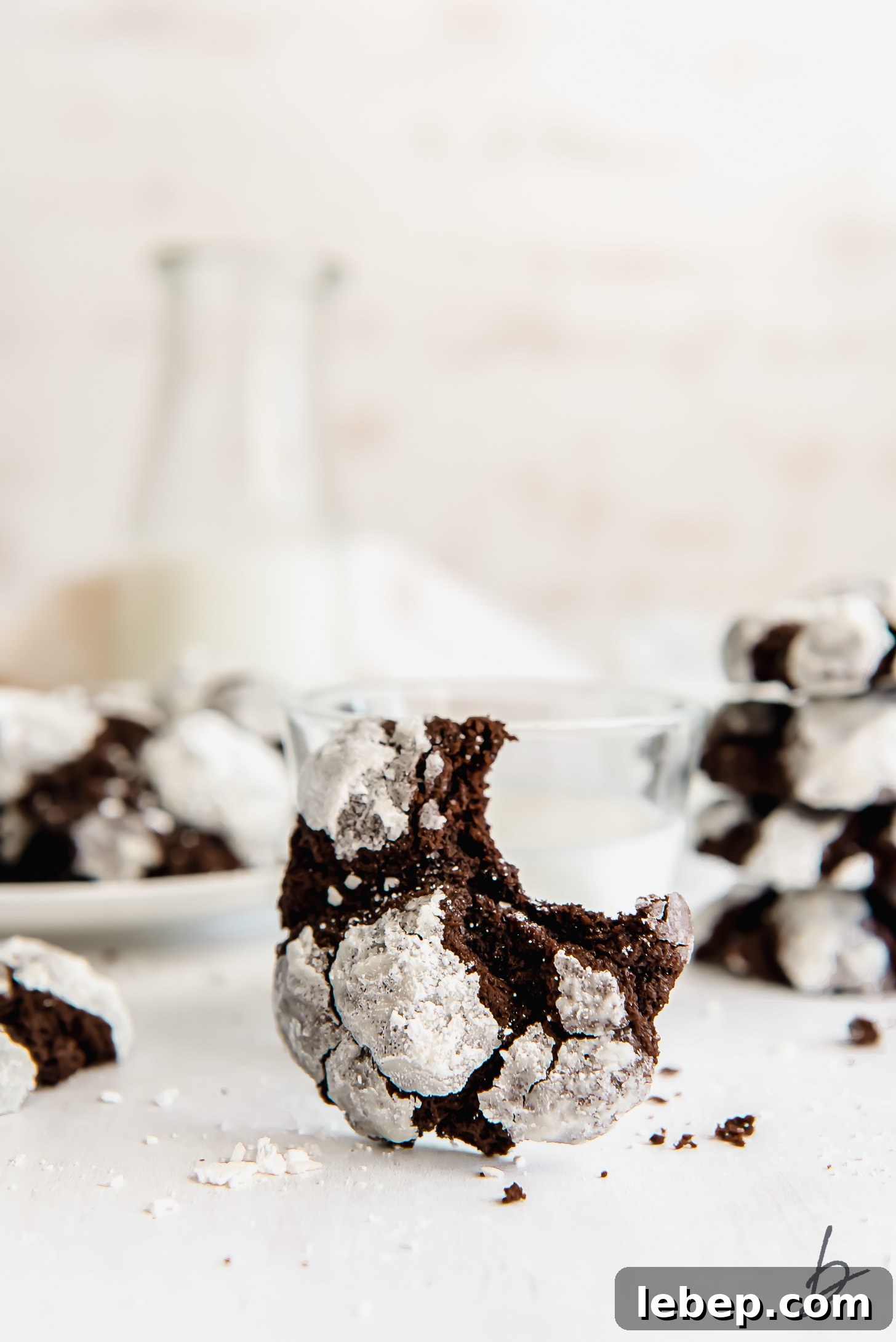 Chocolate Crinkle Cookies Recipe — Soft Fudgy Cookies in Minutes 5 chocolate crinkle cookie with a bite leaning against glass of milk