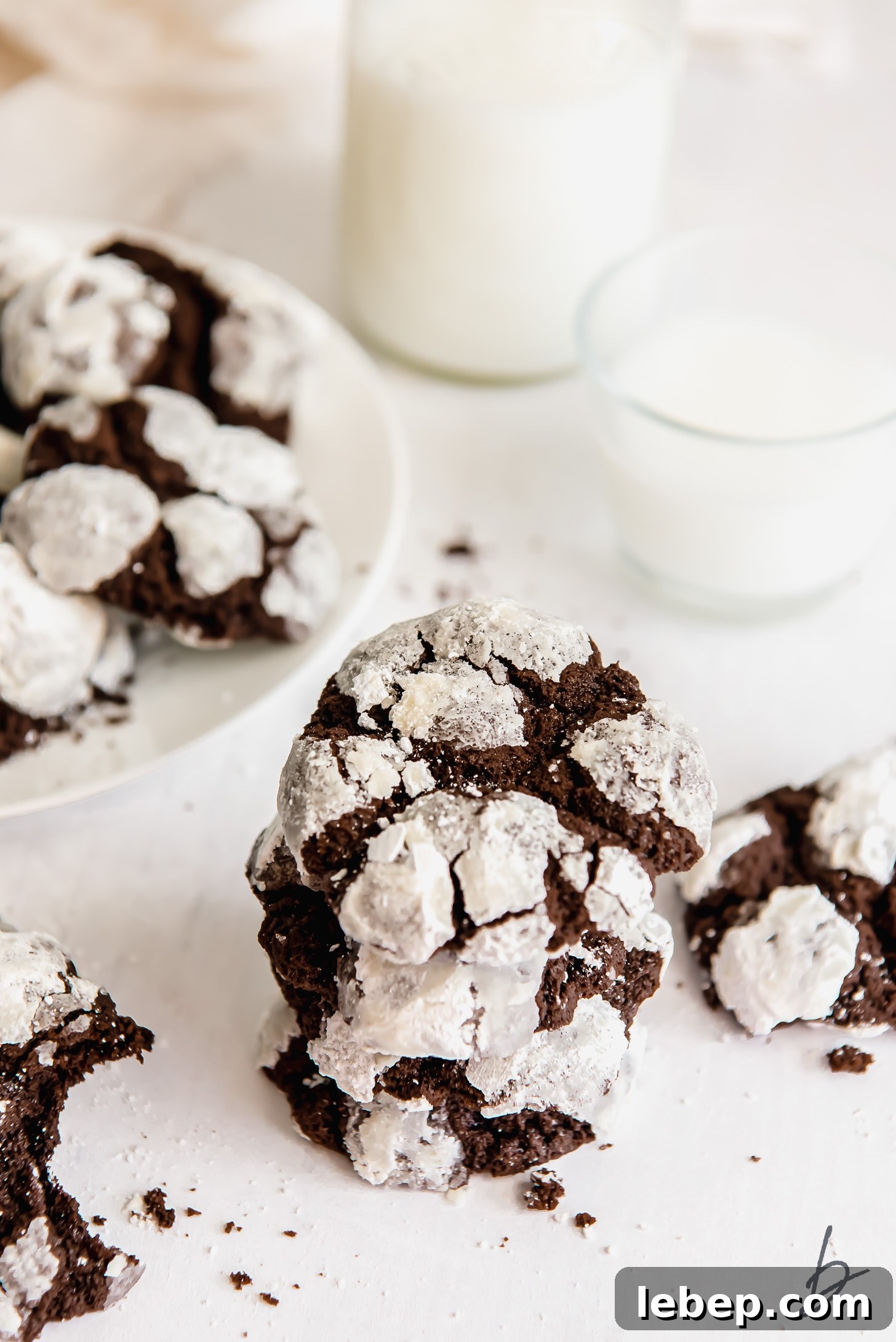 Chocolate Crinkle Cookies Recipe — Soft Fudgy Cookies in Minutes 7 stack of chocolate crinkle cookies covered in powdered sugar