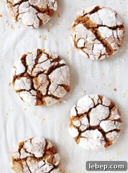 gingerbread crinkle cookies coated in powdered sugar on parchment paper