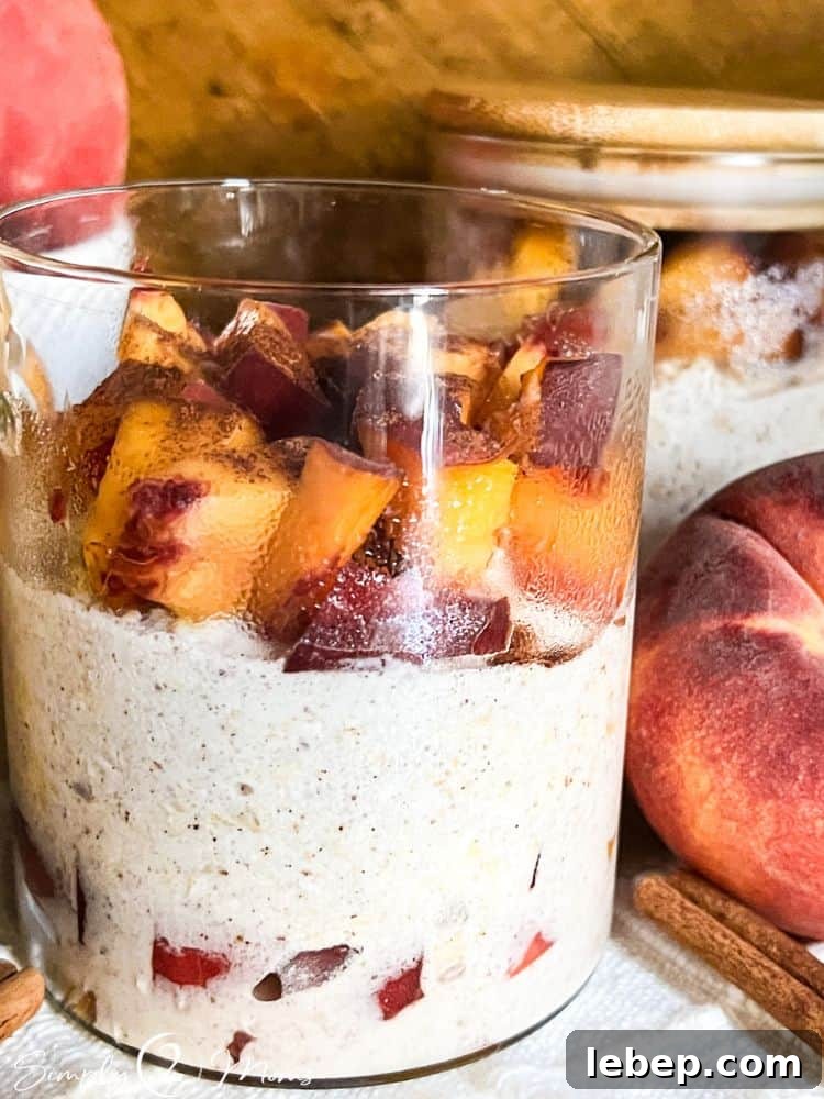 Peach Cobbler Overnight Oats (THM-E) — Make Ahead Recipe 2 No sugar added peach cobbler overnight oats with Greek yogurt in glass jars with attached bamboo spoons.