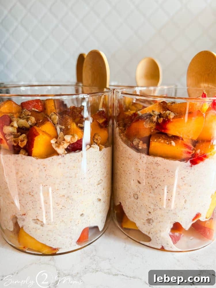 Peach Cobbler Overnight Oats (THM-E) — Make Ahead Recipe 3 Peach cobbler overnight oats with Greek yogurt in glass jars with attached bamboo spoons.