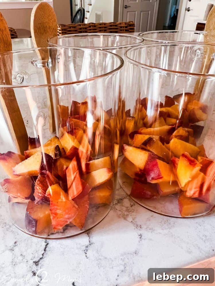 Peach Cobbler Overnight Oats (THM-E) — Make Ahead Recipe 6 Glass jars with attached bamboo spoons with diced peaches inside.