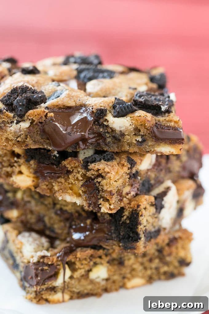 A stack of blondies filled with chocolate chunks and chopped cookies.