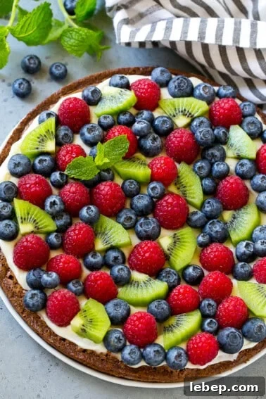 Brownie pizza topped with cream cheese frosting and fresh fruit.