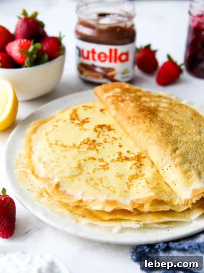 a stack of homemade crepes on a plate with toppings