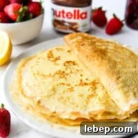 a stack of homemade crepes on a plate with toppings