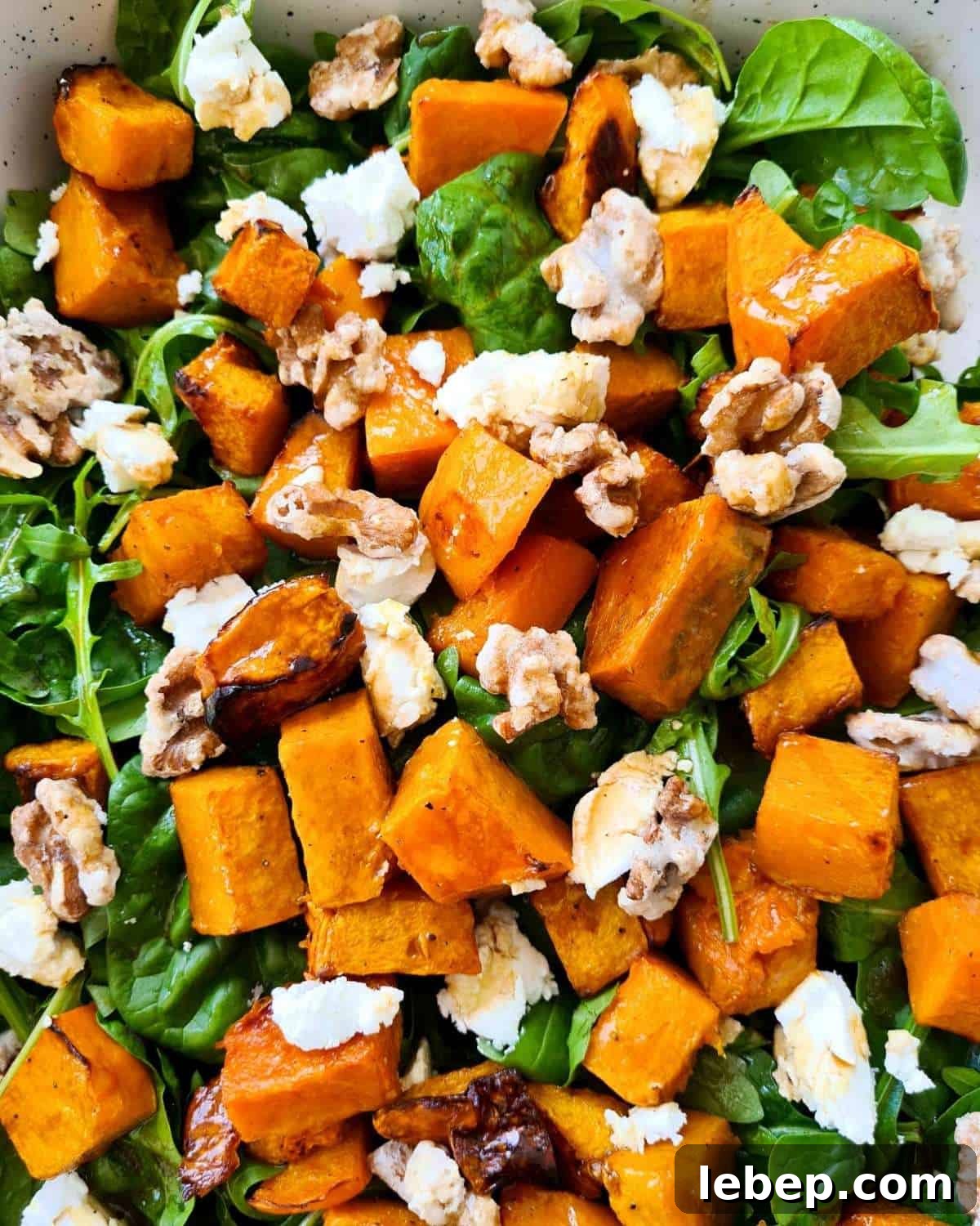 Roasted Pumpkin, Spinach & Goat Cheese Salad Recipe 6 Close up of a large serving dish of pumpkin salad with lots of walnuts and pumpkin