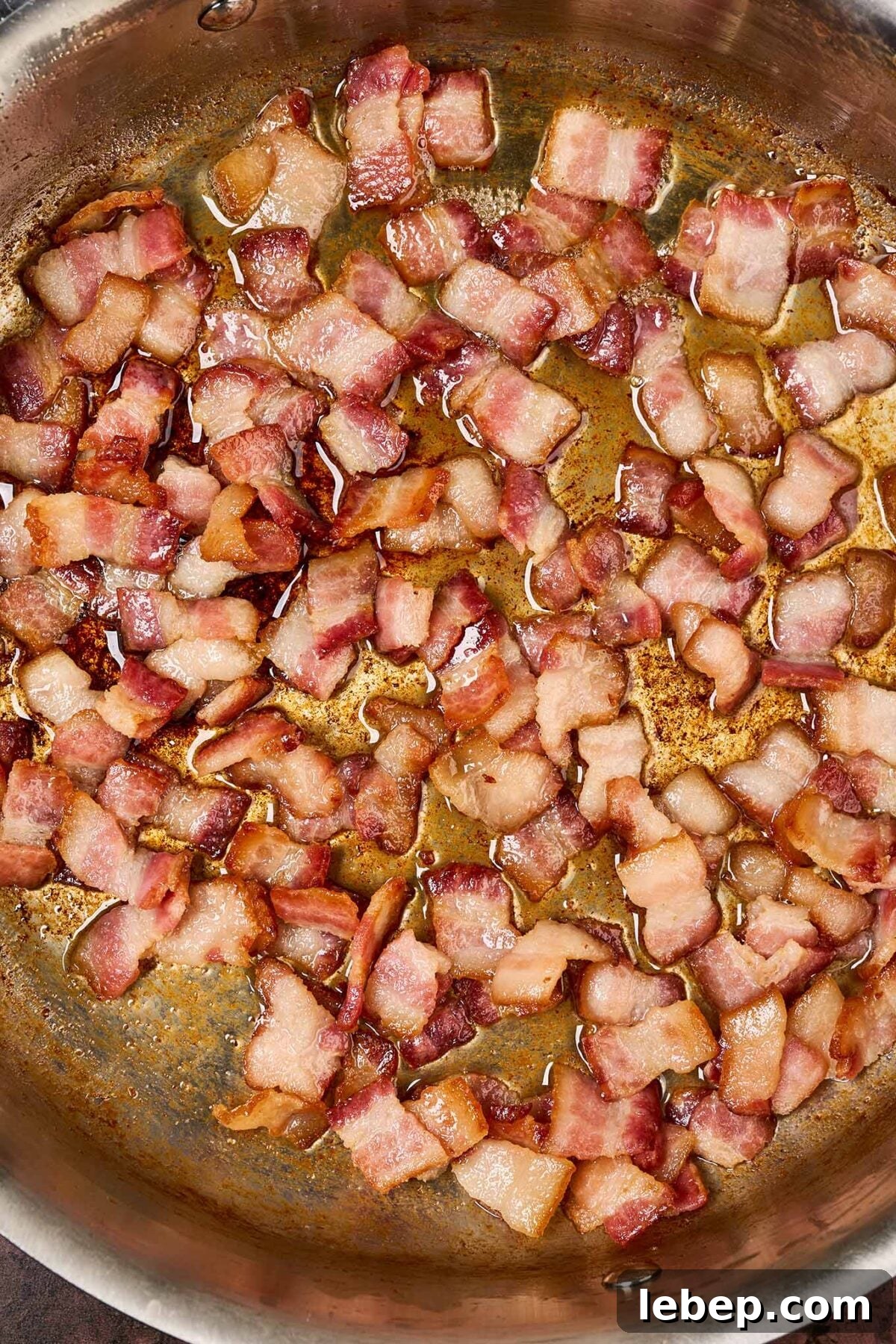 Southern-Style Green Beans with Bacon and Garlic 4 A frying pan filled with pieces of partially cooked, thick-cut bacon.