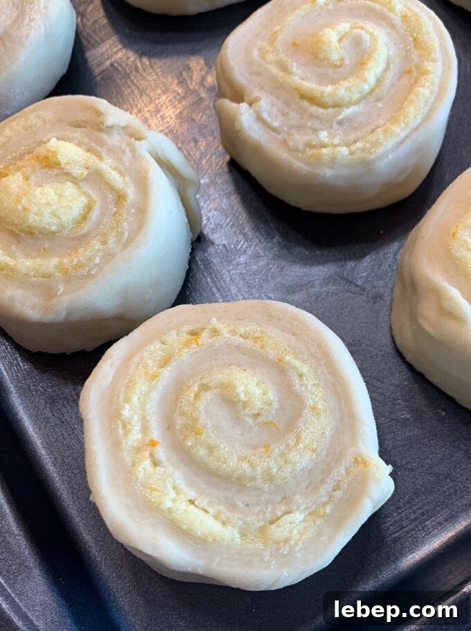 Unbaked overnight orange rolls on a baking sheet.