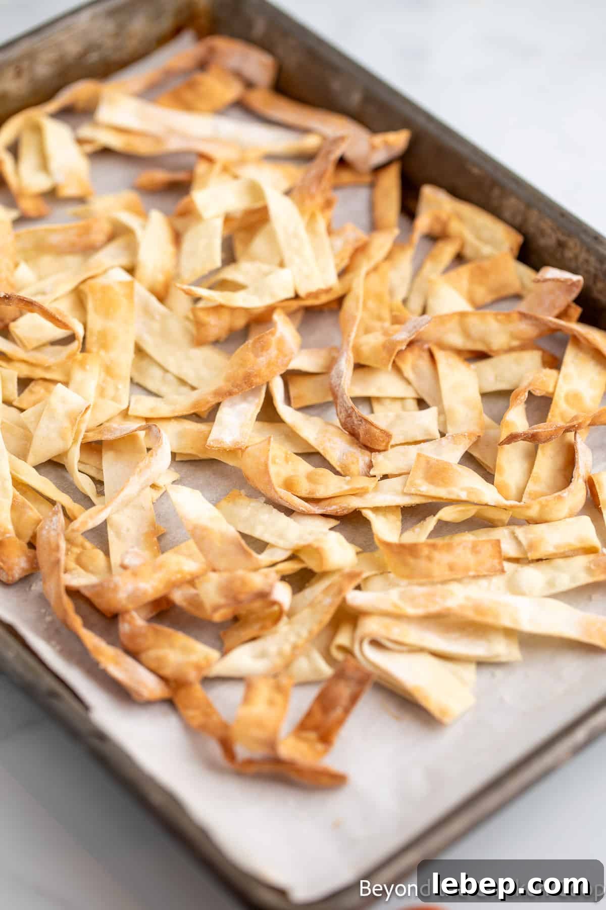 Crispy Asian Chicken Salad with Sesame Ginger Dressing 7 Crispy wonton wrappers on a baking sheet.